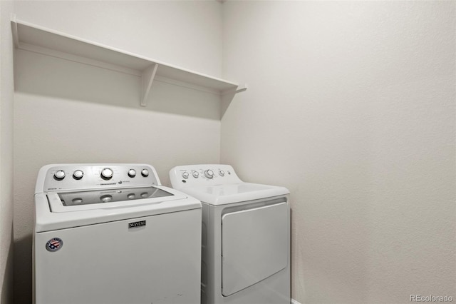 clothes washing area featuring laundry area and washer and clothes dryer