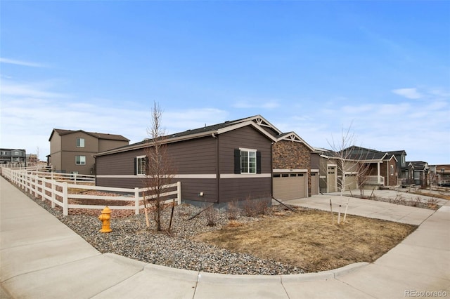 view of front facade featuring a garage, concrete driveway, and fence