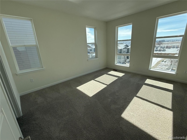 spare room with dark colored carpet