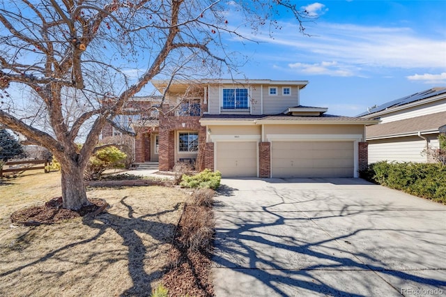 view of front of home featuring a garage, concrete driveway, and brick siding