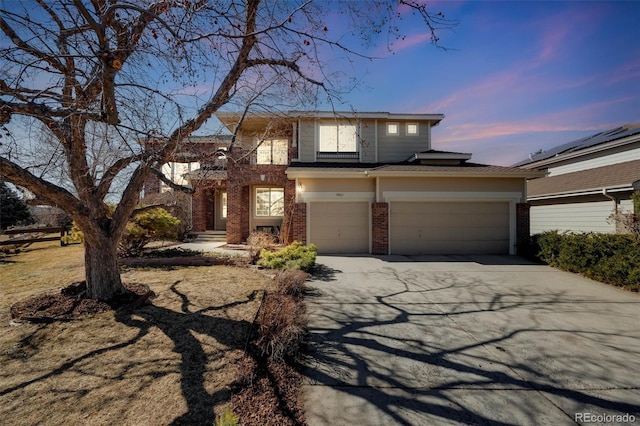 view of front of home with driveway, brick siding, and an attached garage