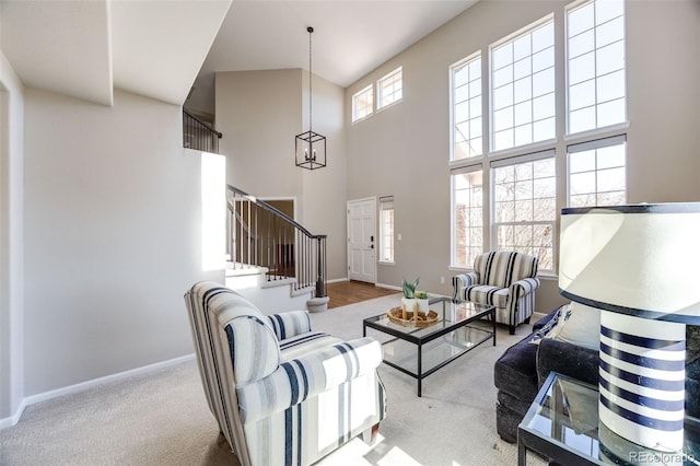 living room featuring a high ceiling, carpet, stairs, and baseboards