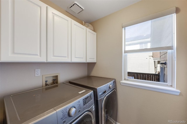 clothes washing area with cabinet space, plenty of natural light, visible vents, and washer and dryer