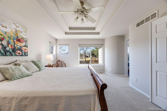 bedroom with a raised ceiling, visible vents, a ceiling fan, carpet flooring, and baseboards