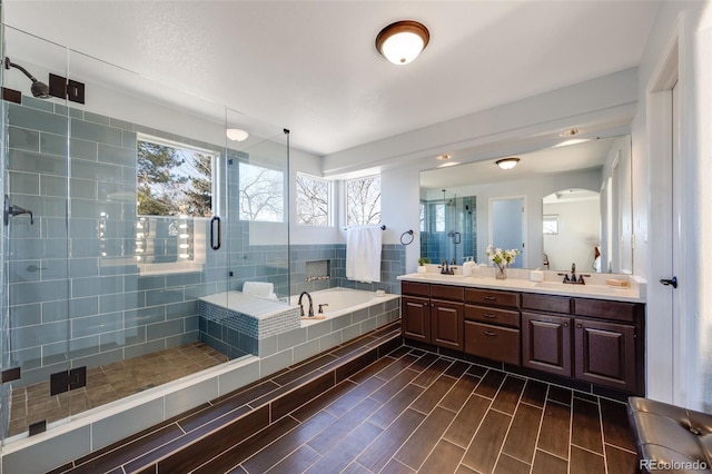 bathroom featuring wood finish floors, a stall shower, a sink, and a bath