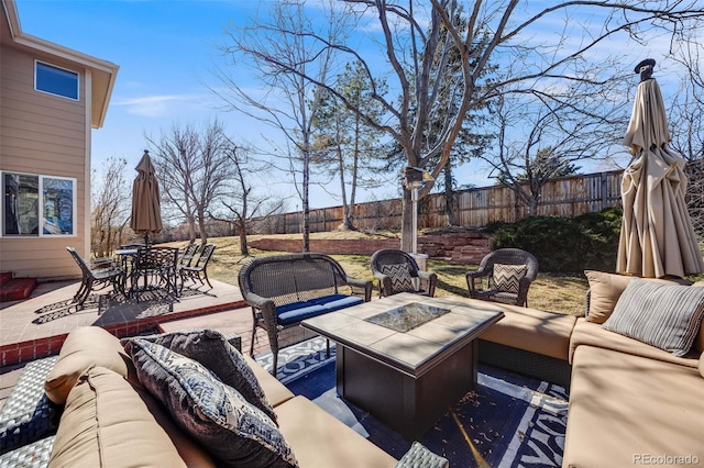 view of patio featuring an outdoor living space with a fire pit, outdoor dining space, and fence