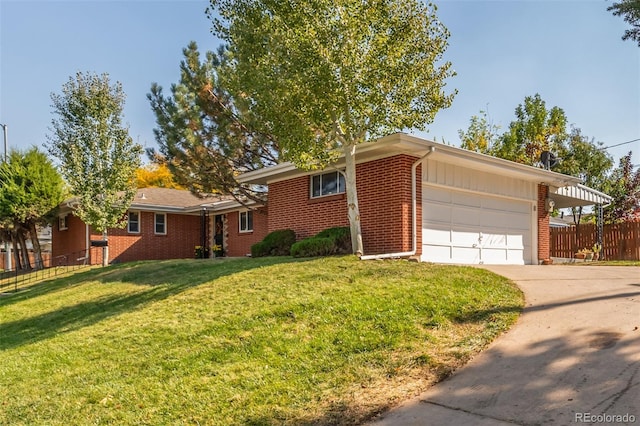 view of front of home with driveway, brick siding, an attached garage, fence, and a front yard