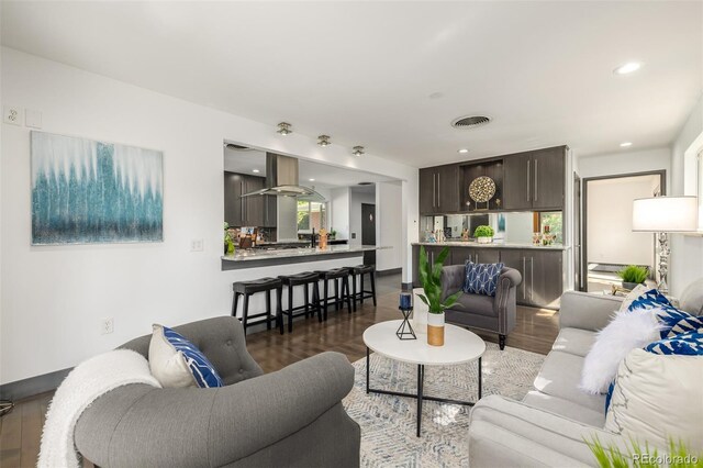 living area featuring recessed lighting, visible vents, and wood finished floors