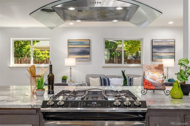 kitchen with light stone counters, plenty of natural light, visible vents, and stainless steel gas stove