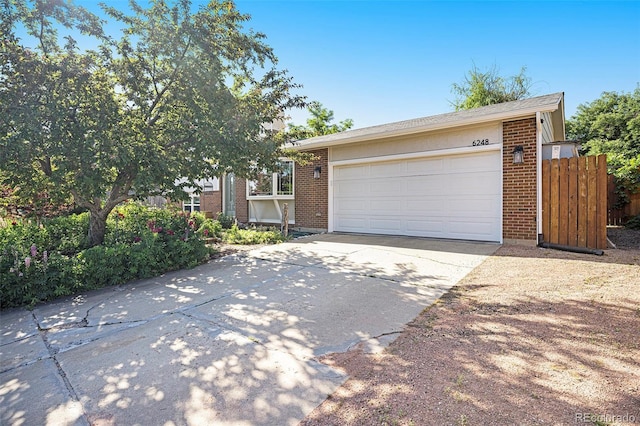 6248 W 75th, Arvada, CO 80003 - view of front of home with brick siding, driveway, and a garage