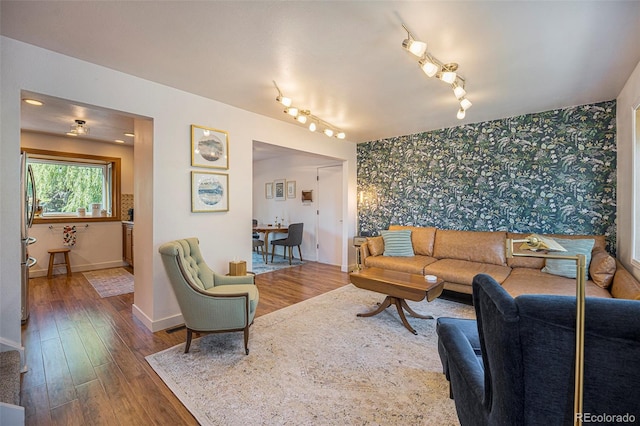6248 W 75th, Arvada, CO 80003 - living room with wallpapered walls, an accent wall, wood-type flooring, and rail lighting
