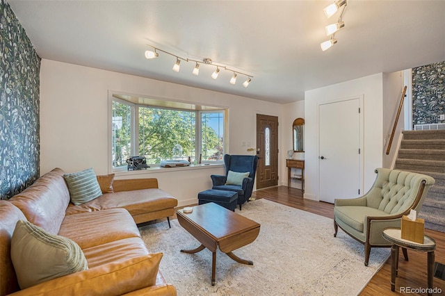 6248 W 75th, Arvada, CO 80003 - living area with wallpapered walls, wood finished floors, track lighting, and stairway