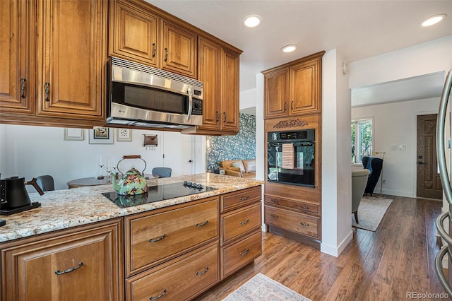 6248 W 75th, Arvada, CO 80003 - kitchen featuring black appliances, brown cabinets, light stone countertops, and recessed lighting