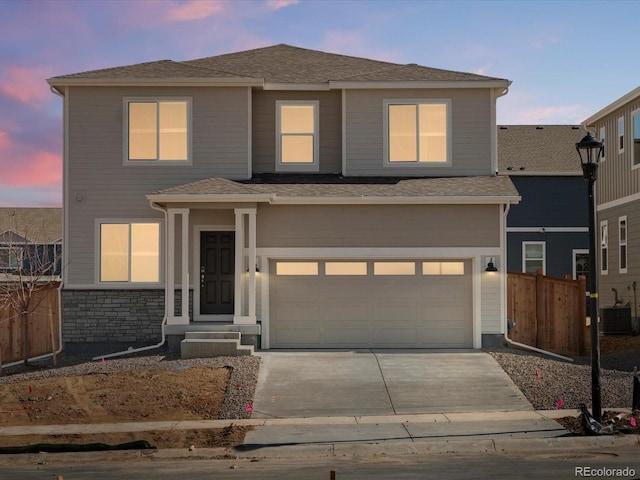 traditional-style home featuring an attached garage, fence, central air condition unit, stone siding, and driveway