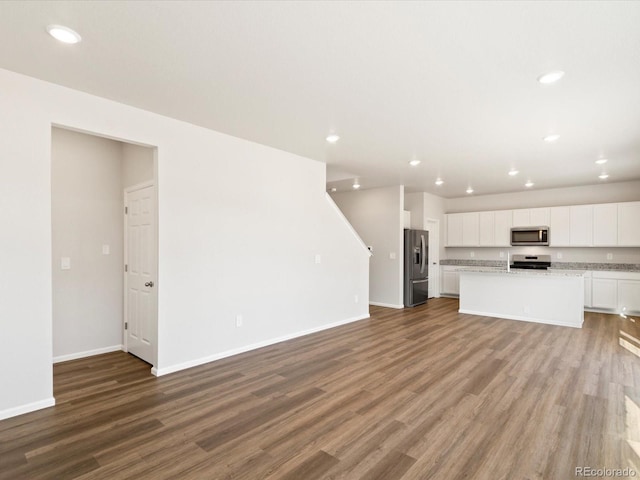 unfurnished living room featuring recessed lighting, baseboards, and wood finished floors