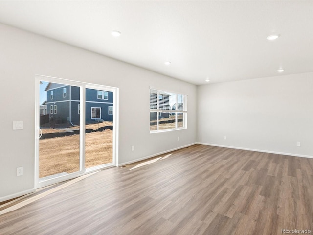 unfurnished room featuring recessed lighting, baseboards, and wood finished floors