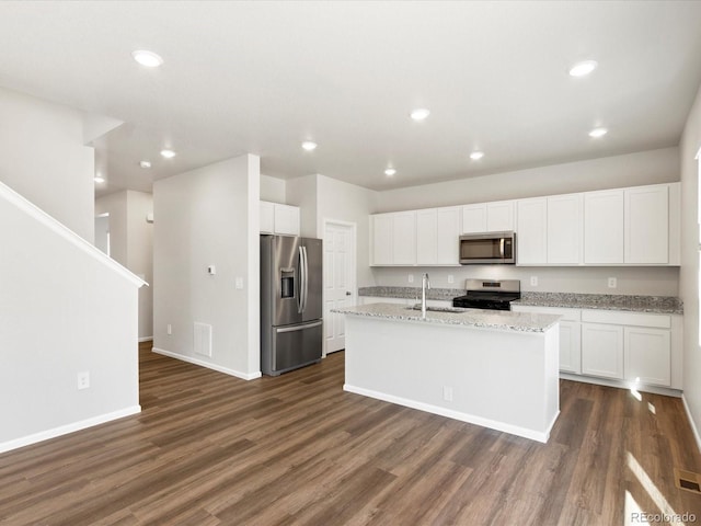 kitchen with a sink, stainless steel appliances, dark wood finished floors, and white cabinetry