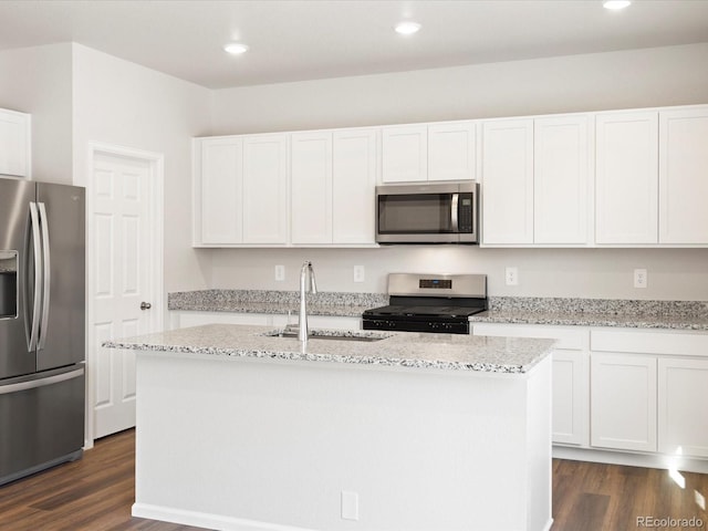 kitchen featuring a center island with sink, a sink, light stone counters, dark wood-style floors, and stainless steel appliances