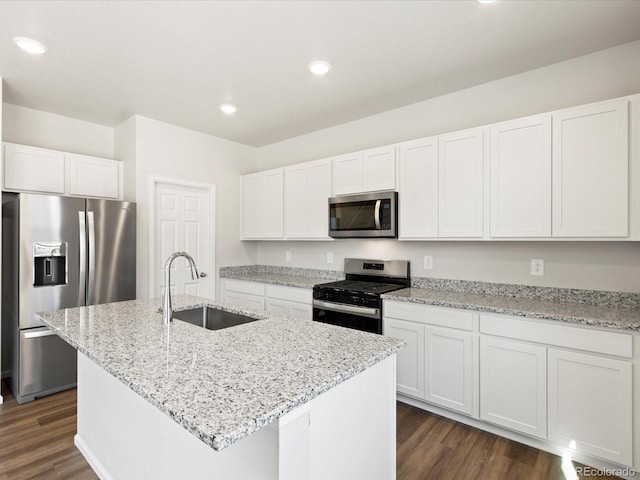 kitchen with a sink, stainless steel appliances, dark wood-type flooring, and white cabinetry