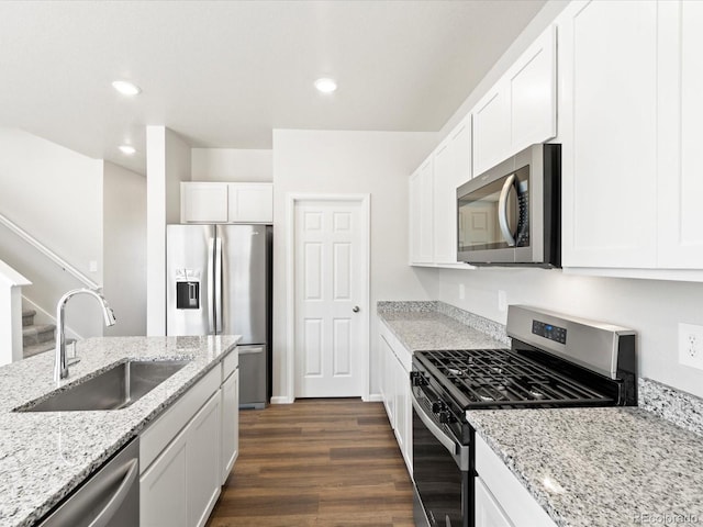 kitchen with dark wood finished floors, recessed lighting, appliances with stainless steel finishes, white cabinetry, and a sink