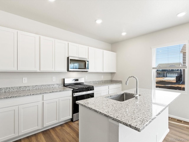 kitchen featuring dark wood-style flooring, white cabinets, appliances with stainless steel finishes, and a sink