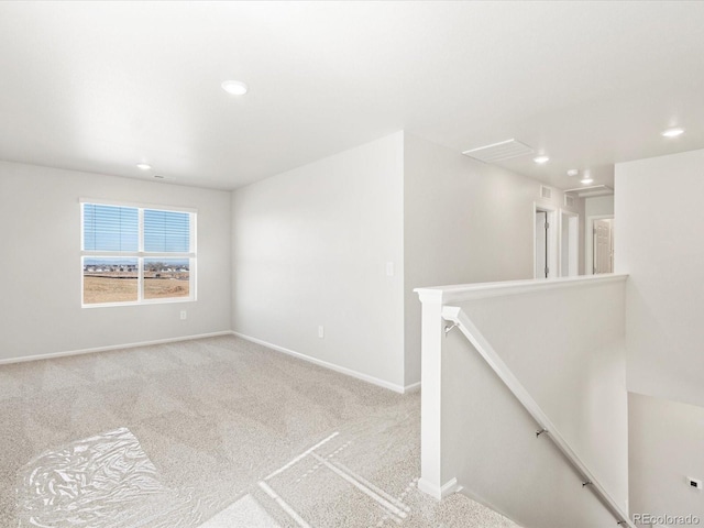 carpeted empty room featuring recessed lighting and baseboards