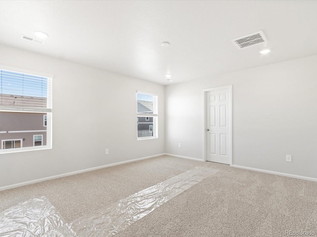 empty room featuring visible vents, recessed lighting, baseboards, and carpet