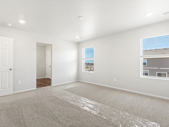 unfurnished room featuring recessed lighting, visible vents, baseboards, and carpet