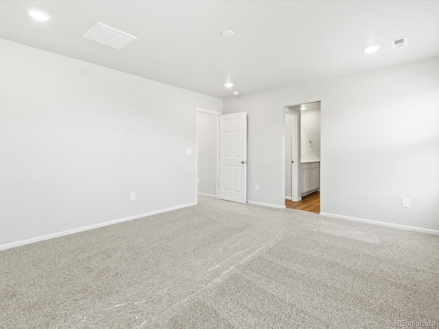 unfurnished bedroom with visible vents, recessed lighting, connected bathroom, carpet floors, and baseboards