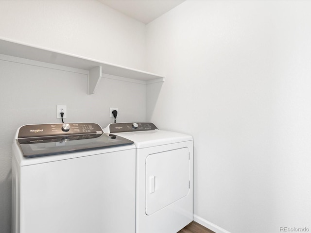 washroom with laundry area, wood finished floors, baseboards, and washer and clothes dryer