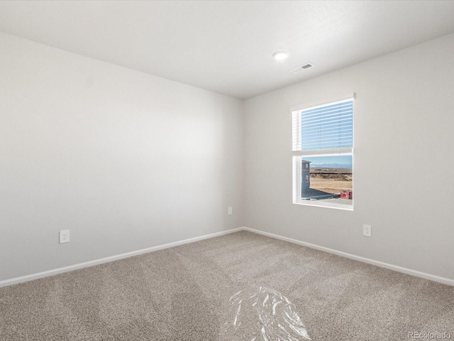 empty room featuring visible vents, baseboards, and carpet