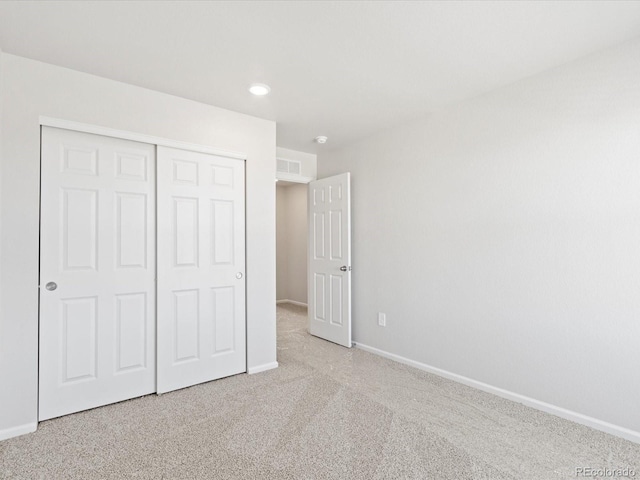 unfurnished bedroom with a closet, baseboards, carpet, and visible vents