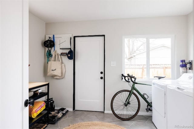 washroom with light tile patterned floors and washing machine and clothes dryer