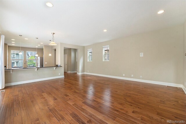 5434 N Xenia St, Denver, CO 80238 - unfurnished living room with dark wood-style floors and recessed lighting