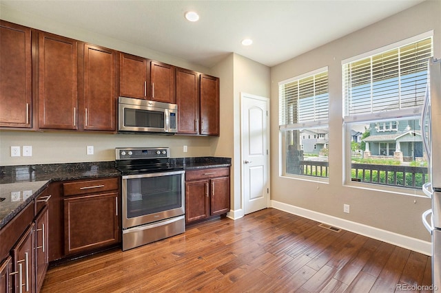 5434 N Xenia St, Denver, CO 80238 - kitchen featuring appliances with stainless steel finishes, dark wood finished floors, recessed lighting, and dark stone counters