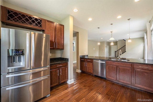 5434 N Xenia St, Denver, CO 80238 - kitchen with appliances with stainless steel finishes, dark wood-type flooring, dark stone countertops, recessed lighting, and decorative light fixtures