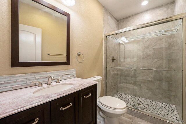 5434 N Xenia St, Denver, CO 80238 - bathroom with vanity, a stall shower, a textured wall, and tile patterned floors