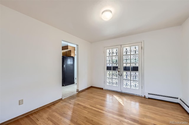 unfurnished room with french doors, baseboards, and light wood-style flooring