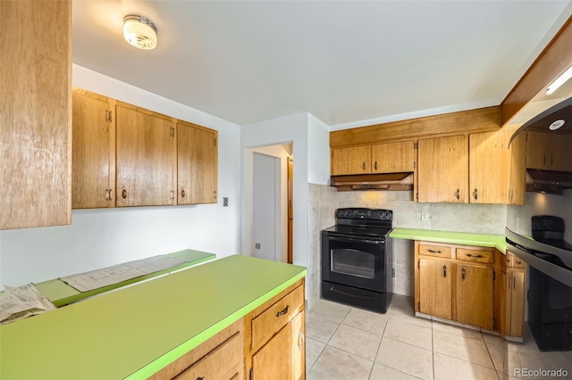 kitchen featuring black / electric stove, light tile patterned flooring, light countertops, under cabinet range hood, and backsplash