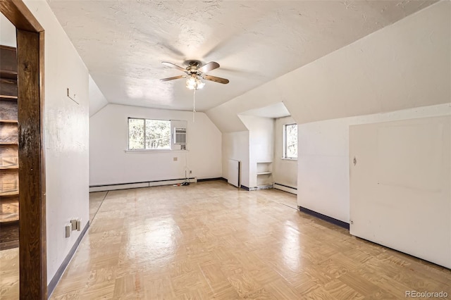 bonus room with lofted ceiling, a baseboard heating unit, ceiling fan, and a healthy amount of sunlight