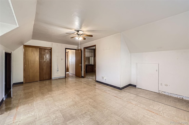 additional living space with vaulted ceiling, baseboards, and ceiling fan