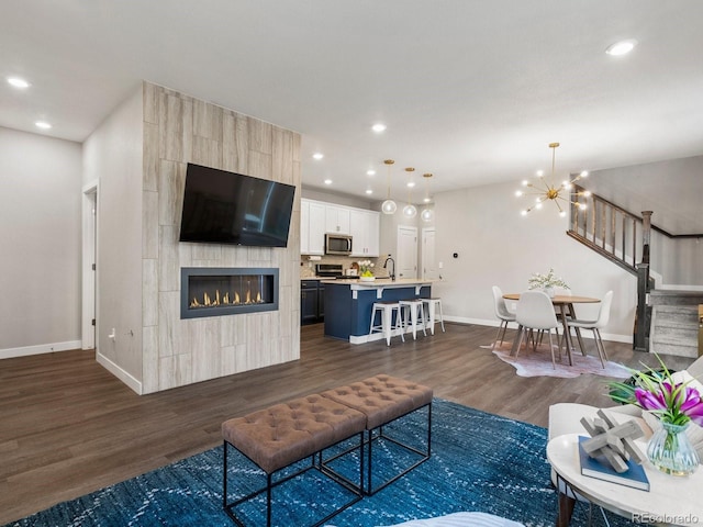 229 W Jamison Ct, Littleton, CO 80120 - living area featuring dark wood-type flooring, recessed lighting, a chandelier, stairway, and a tile fireplace