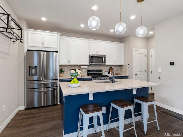 229 W Jamison Ct, Littleton, CO 80120 - kitchen with appliances with stainless steel finishes, dark wood finished floors, tasteful backsplash, white cabinets, and an island with sink