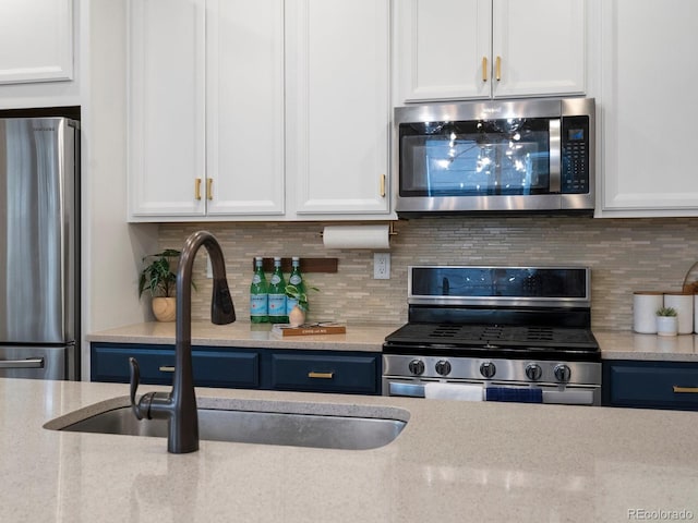 229 W Jamison Ct, Littleton, CO 80120 - kitchen featuring stainless steel appliances, white cabinets, and tasteful backsplash
