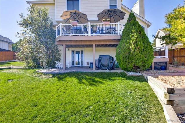 back of property featuring a patio area, a lawn, and a deck