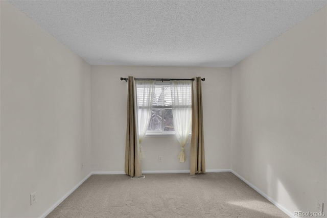 spare room featuring carpet flooring and a textured ceiling