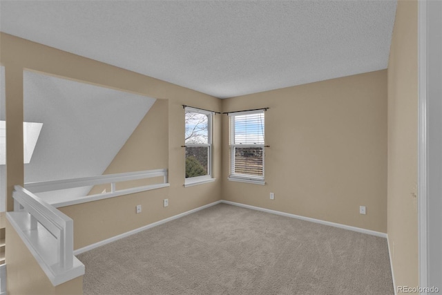 unfurnished room featuring light carpet and a textured ceiling