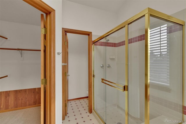 bathroom featuring walk in shower and wood walls