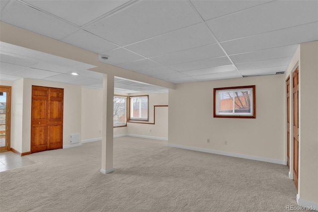 basement with light colored carpet and a drop ceiling