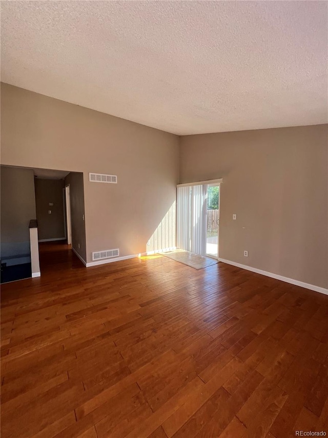 unfurnished room featuring a textured ceiling and dark wood-type flooring